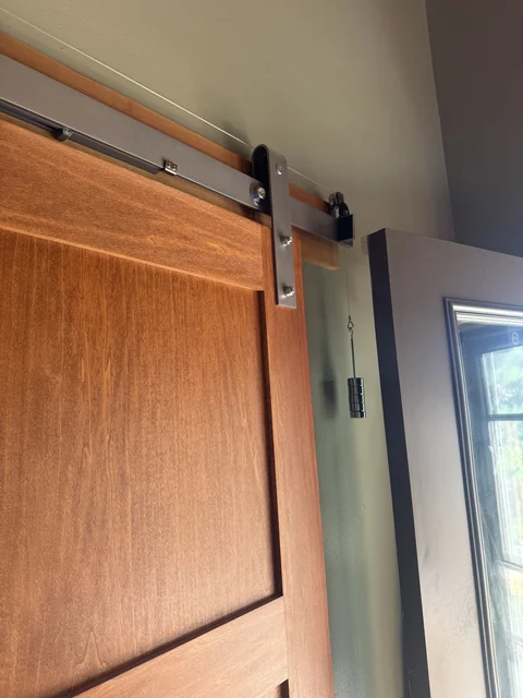 I added pulleys and precise counter weights to automagically close the barn door. They don’t make kits for this. Dumb.  I've recreated this on our utility room door as well.  No grandbabies allowed in the danger room :-)